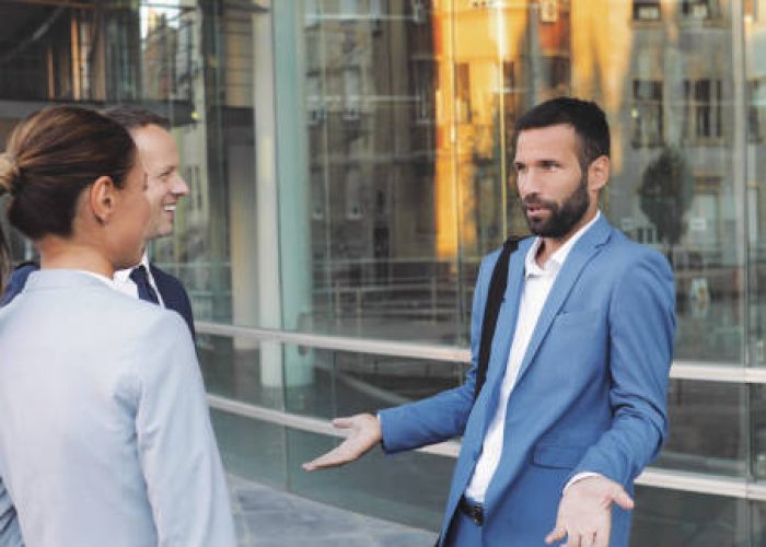 Three business colleagues having discussion while walking outdoors